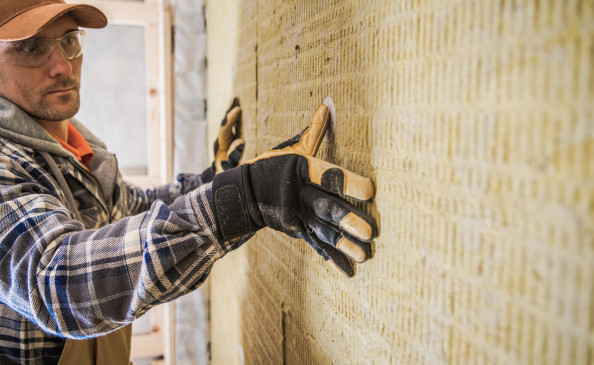 Arbeiter dämmt Wand mit Mienralwolle | Der Dämmstoff | Foto von welcomia auf istockphoto.com