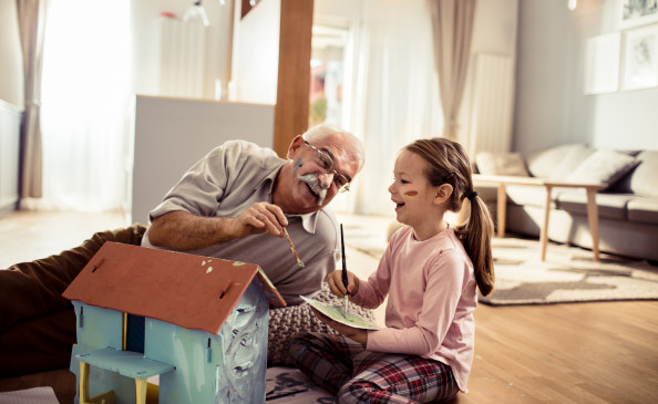 Großvater und Enkelin bemalen ein Haus | Foto von vorDa auf istockphoto.com