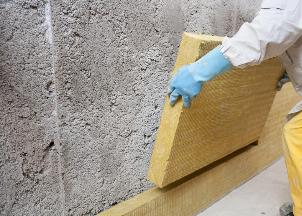 Arbeiter dämmt Hausfassade mit Mineralwolle | Der Sämmstoff | Foto von alexandrumagurean – istockphoto.com