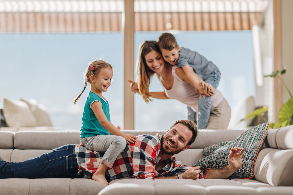 Junge Familie spielt im Wohnzimmer | Behaglichkeit zu Hause im Sommer | Der Dämmstoff | Foto von skynesher – istockphoto.com